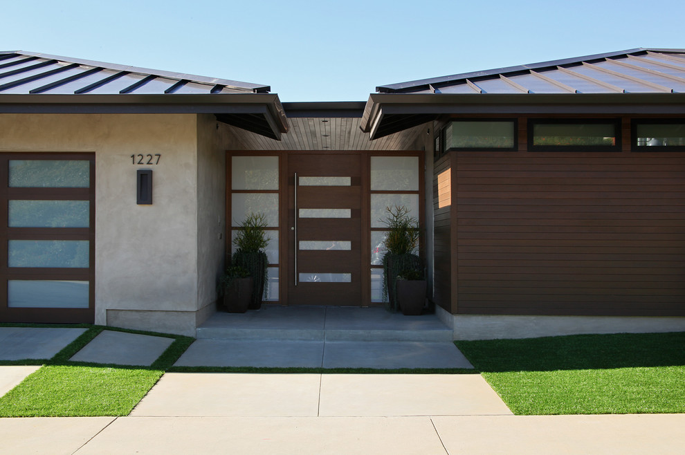 Inspiration for a mid-sized modern one-storey grey house exterior in Orange County with wood siding, a hip roof and a metal roof.