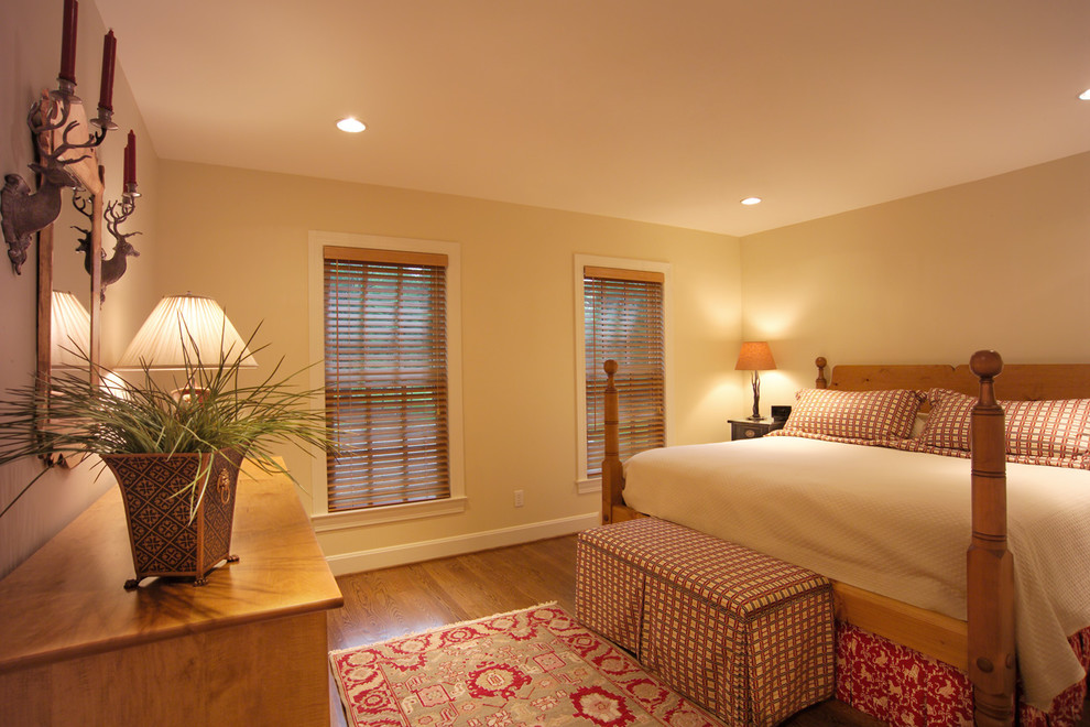 Inspiration for a mid-sized traditional master bedroom in Louisville with yellow walls and medium hardwood floors.