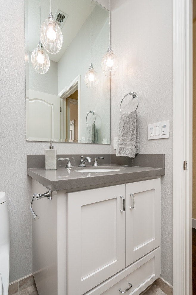 This is an example of a small transitional 3/4 bathroom in San Francisco with an undermount sink, shaker cabinets, grey cabinets, engineered quartz benchtops, an alcove shower, beige tile, porcelain tile, grey walls and porcelain floors.