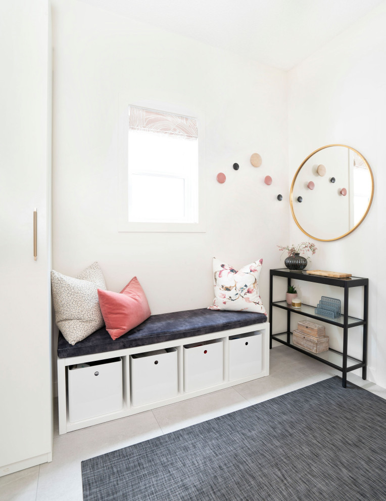 Example of a small transitional medium tone wood floor and brown floor foyer design in Calgary with white walls