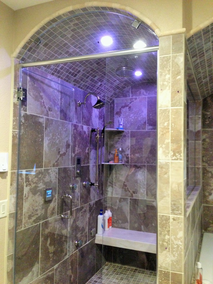 Inspiration for a transitional master multicolored tile and porcelain tile porcelain tile drop-in bathtub remodel with an integrated sink, recessed-panel cabinets, distressed cabinets, solid surface countertops and beige walls