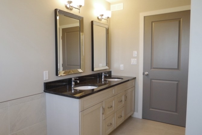 Small transitional master white tile and porcelain tile alcove shower photo with an undermount sink, shaker cabinets, white cabinets, granite countertops, beige walls, a two-piece toilet and a drop-in sink