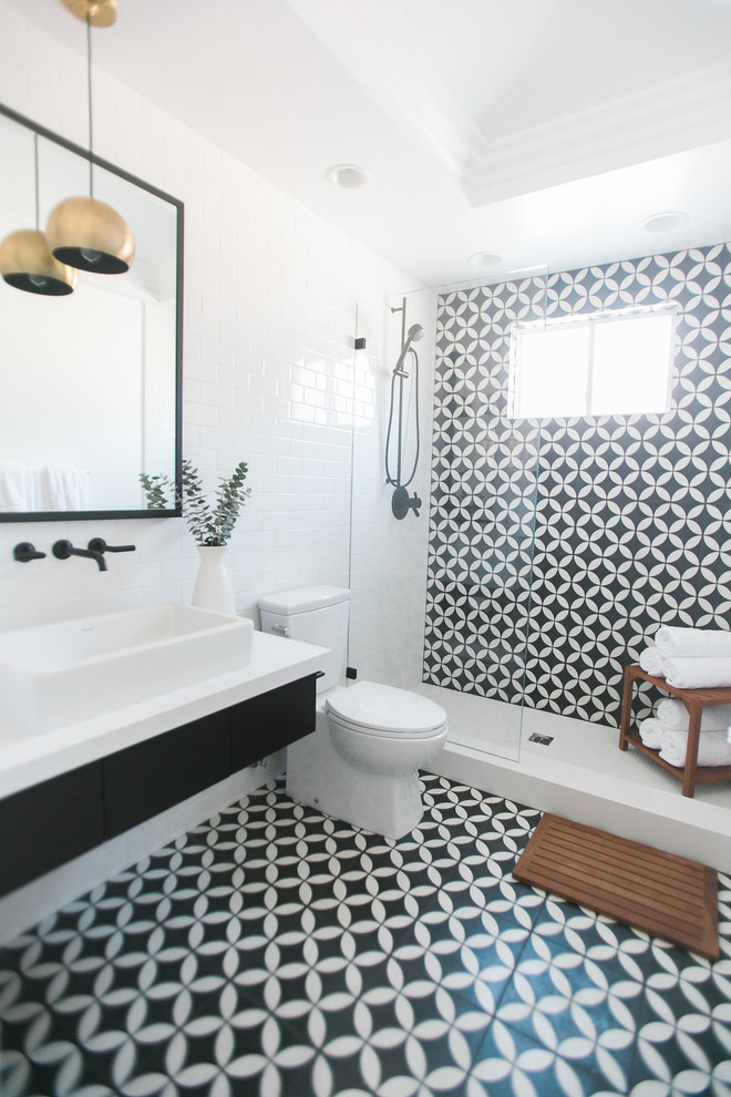 This is an example of a mid-sized midcentury 3/4 bathroom in Orange County with flat-panel cabinets, black cabinets, an alcove shower, black and white tile, white walls, mosaic tile floors and a drop-in sink.