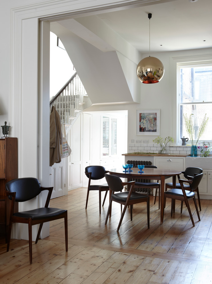 Inspiration for a large transitional kitchen/dining combo in London with light hardwood floors.