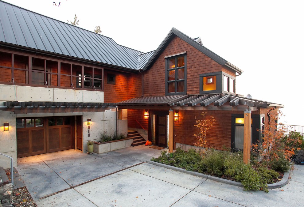 This is an example of a large transitional three-storey brown house exterior in Seattle with wood siding, a gable roof and a metal roof.