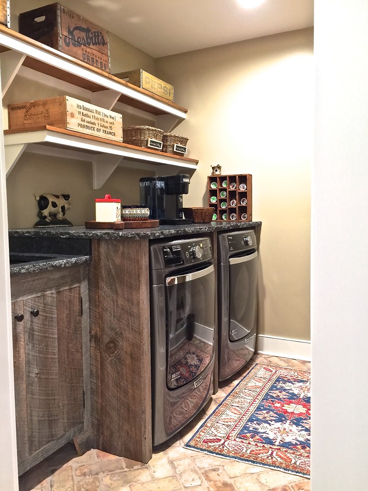 Mid-sized traditional galley dedicated laundry room in Burlington with an undermount sink, flat-panel cabinets, granite benchtops, beige walls, brick floors, a side-by-side washer and dryer and dark wood cabinets.