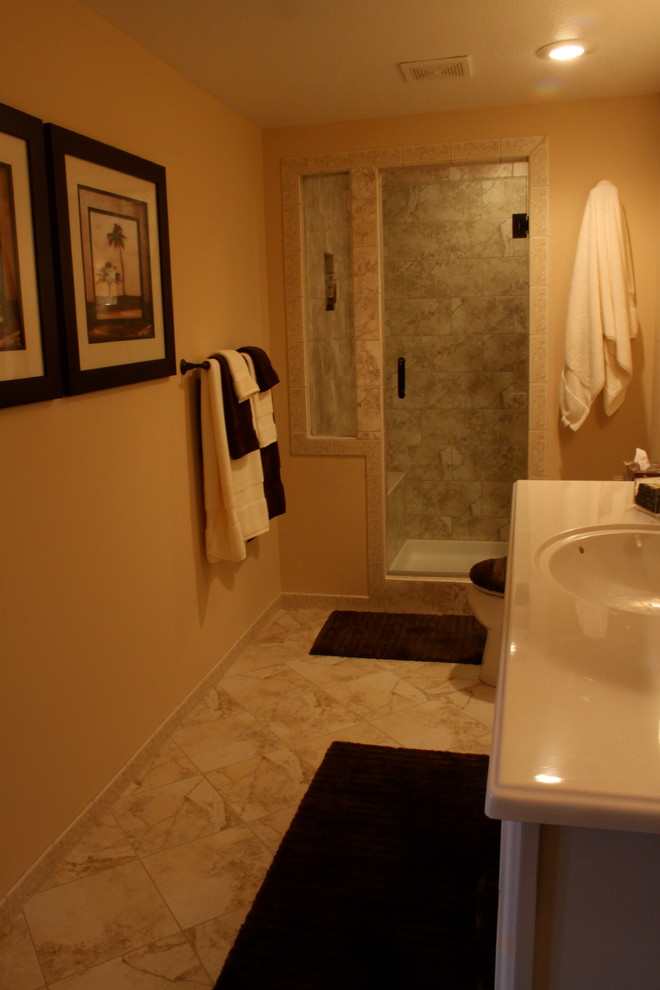 Photo of a mid-sized traditional 3/4 bathroom in Other with an alcove shower, beige walls, marble floors, an integrated sink, multi-coloured floor and a hinged shower door.