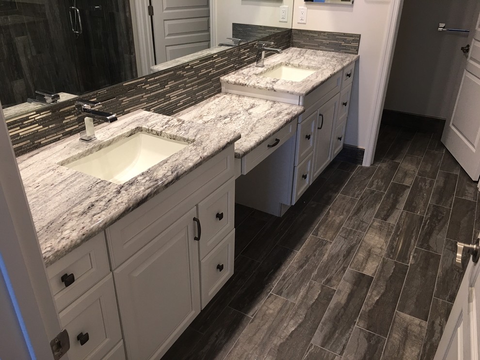 Inspiration for a mid-sized modern master bathroom in Newark with raised-panel cabinets, white cabinets, an alcove shower, a one-piece toilet, gray tile, ceramic tile, white walls, plywood floors, an undermount sink and marble benchtops.