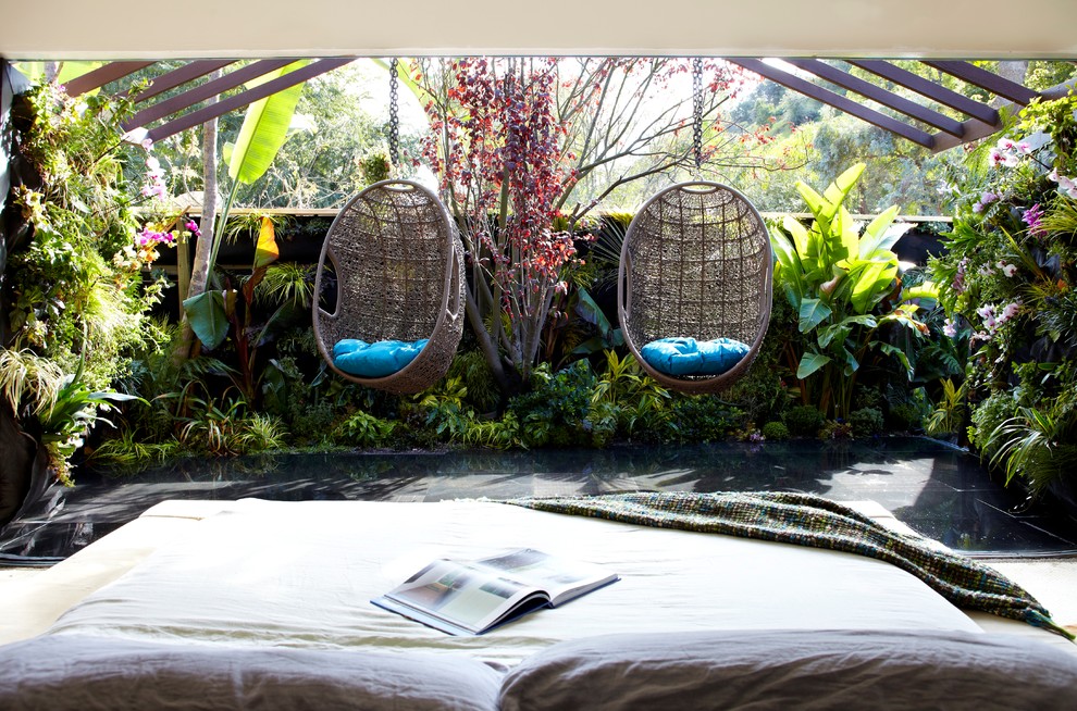 This is an example of a tropical master bedroom in Sydney.