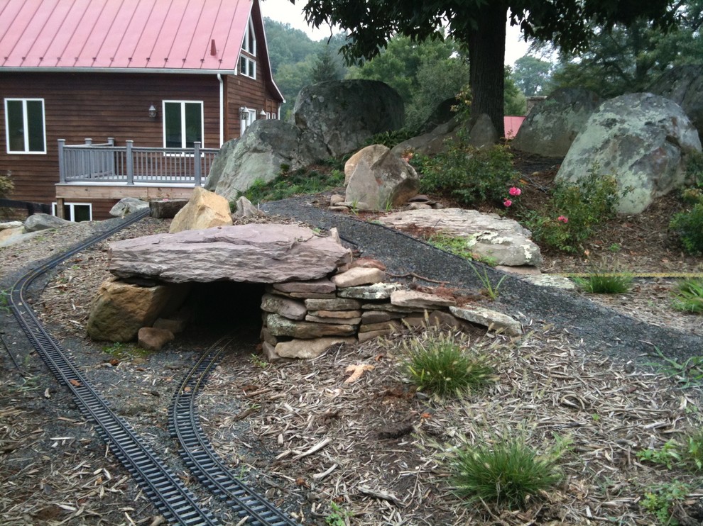 Inspiration for a large rustic partial sun backyard stone formal garden for summer.