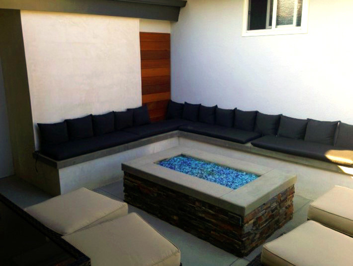 This is an example of a mid-sized transitional backyard patio in Orange County with a fire feature, concrete slab and no cover.