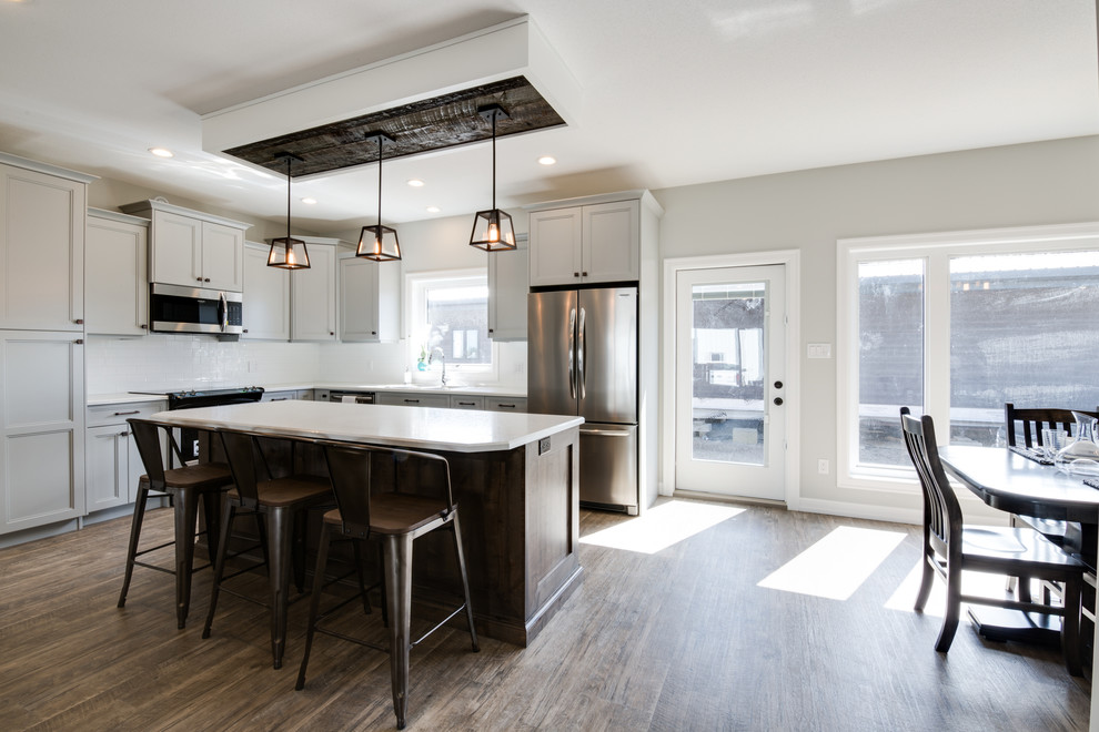 Example of a large transitional l-shaped open concept kitchen design with shaker cabinets, gray cabinets, laminate countertops, stainless steel appliances and an island