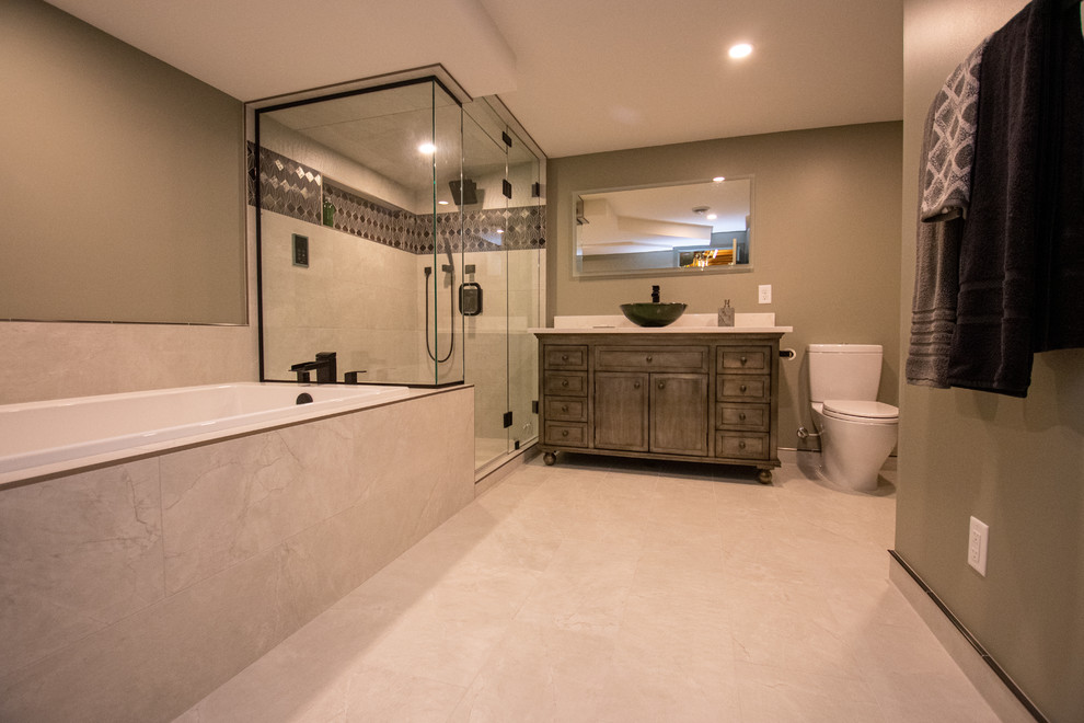 Photo of an expansive contemporary master bathroom in Minneapolis with shaker cabinets, medium wood cabinets, a drop-in tub, a corner shower, a two-piece toilet, multi-coloured tile, ceramic tile, green walls, ceramic floors, a vessel sink, granite benchtops, beige floor, a hinged shower door and white benchtops.