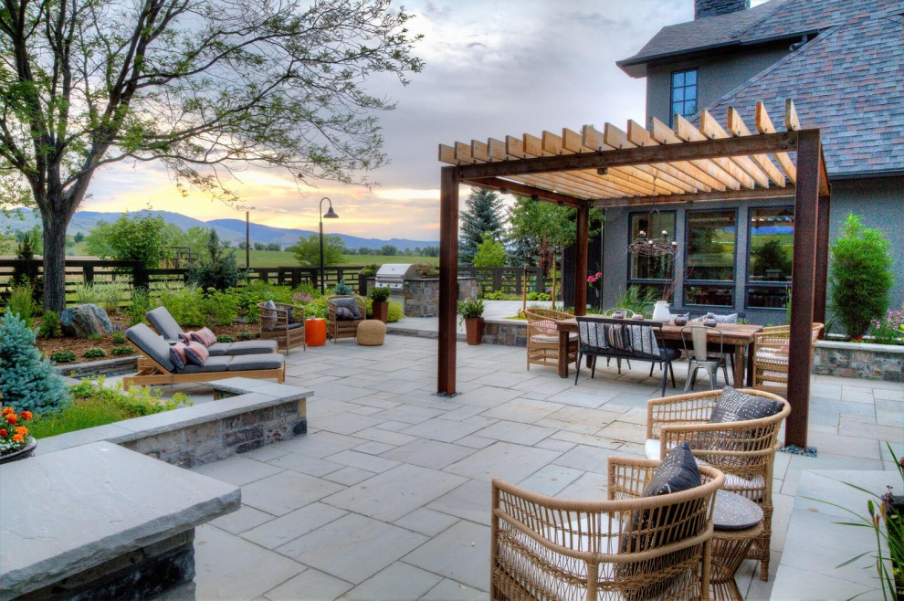 Patio - large country backyard stone patio idea in Denver