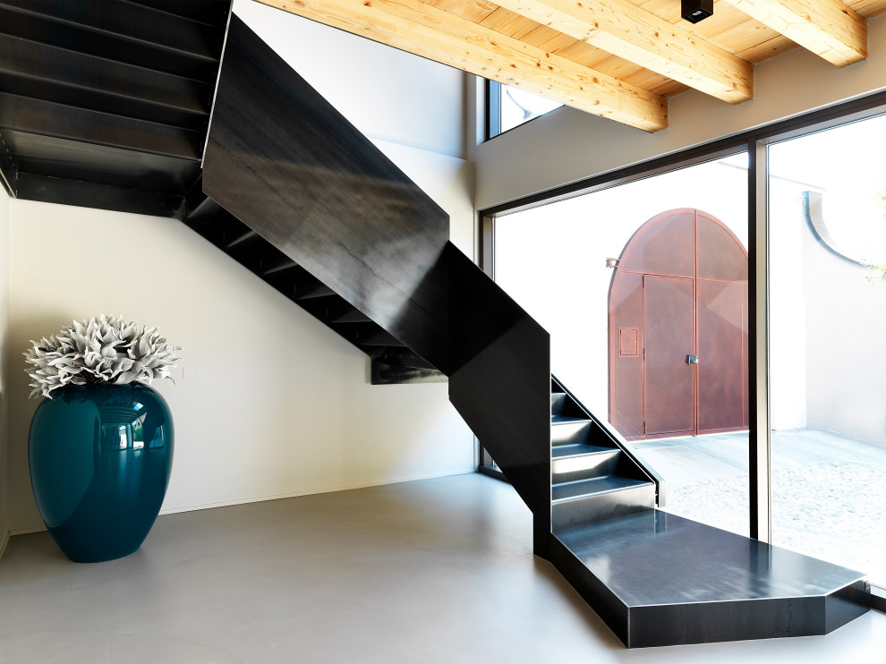 Design ideas for a mid-sized contemporary metal u-shaped staircase in Milan with metal risers and metal railing.