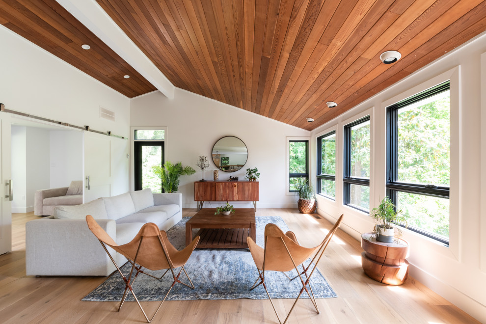 Immagine di un grande soggiorno contemporaneo aperto con pareti bianche, pavimento in legno massello medio e soffitto in perlinato