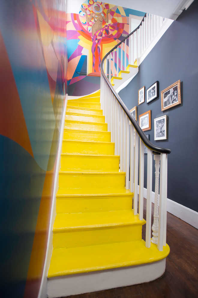This is an example of an eclectic painted wood l-shaped staircase in London with painted wood risers.