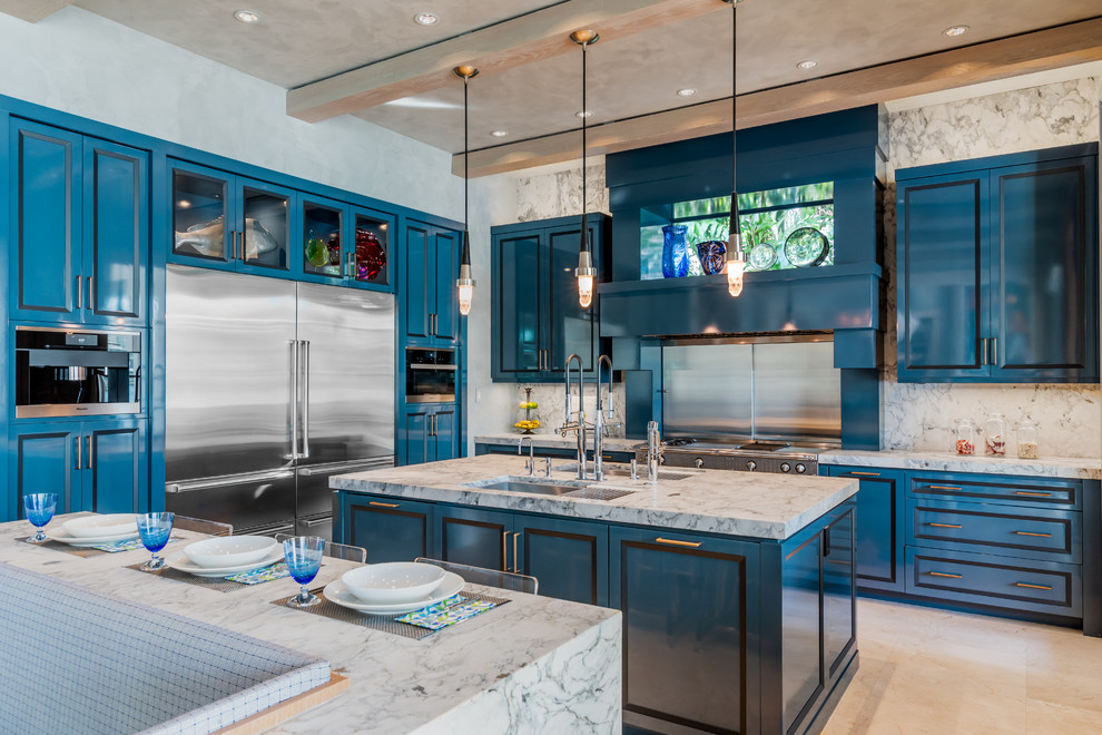 Photo of a mediterranean kitchen in Miami with a double-bowl sink, recessed-panel cabinets, blue cabinets, metallic splashback, stainless steel appliances, multiple islands, beige floor and multi-coloured benchtop.