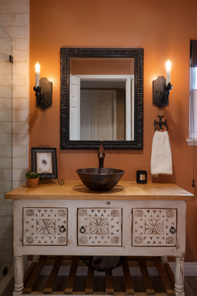 Источник вдохновения для домашнего уюта: маленькая ванная комната в средиземноморском стиле с фасадами островного типа, белыми фасадами, душем в нише, унитазом-моноблоком, бежевой плиткой, керамогранитной плиткой, оранжевыми стенами, полом из винила, душевой кабиной, настольной раковиной, столешницей из дерева, бежевым полом, душем с распашными дверями, коричневой столешницей, тумбой под одну раковину и напольной тумбой для на участке и в саду