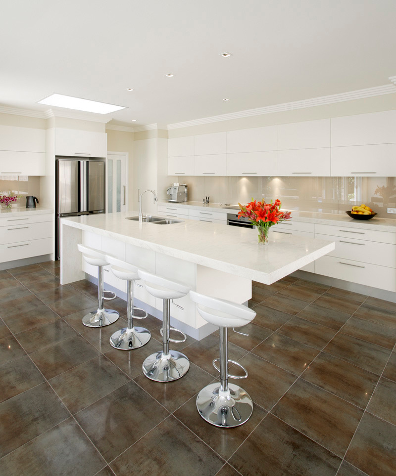 Design ideas for a contemporary l-shaped eat-in kitchen in Sydney with an undermount sink, flat-panel cabinets, white cabinets, recycled glass benchtops and glass sheet splashback.