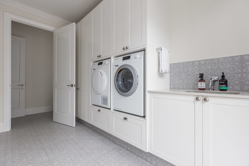 Large traditional galley dedicated laundry room in Gold Coast - Tweed with a drop-in sink, shaker cabinets, white cabinets, quartz benchtops, white walls, porcelain floors, a side-by-side washer and dryer and white floor.