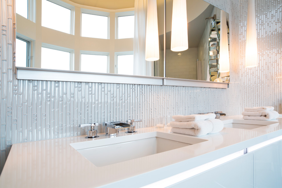 This is an example of a large contemporary master bathroom in Portland with an undermount sink, white cabinets, a double shower, white tile, glass tile, white walls and porcelain floors.