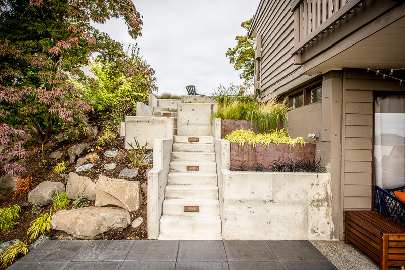 This is an example of a contemporary backyard garden in Seattle with concrete pavers.