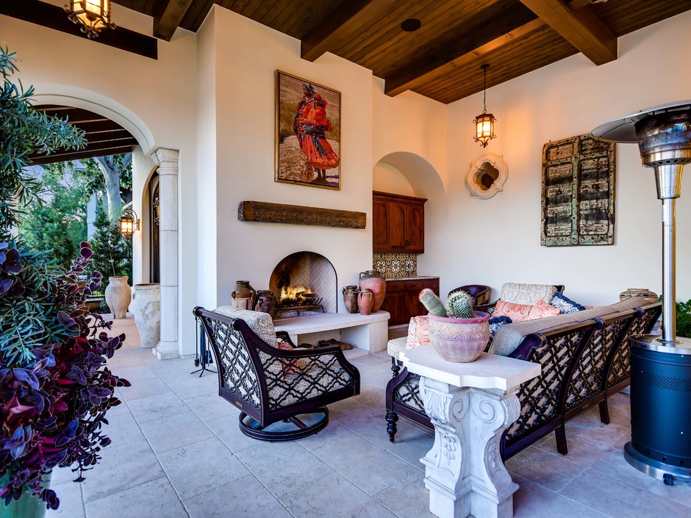 Inspiration for a mediterranean backyard stone patio remodel in Austin with a fireplace and a roof extension