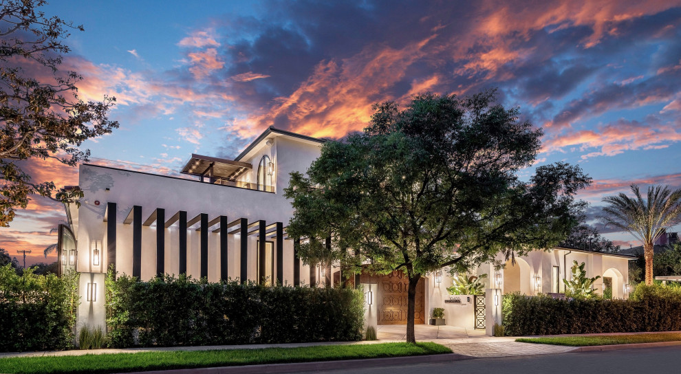 Großes, Zweistöckiges Mediterranes Einfamilienhaus mit Putzfassade, weißer Fassadenfarbe, Satteldach, Schindeldach, rotem Dach und Schindeln in Los Angeles