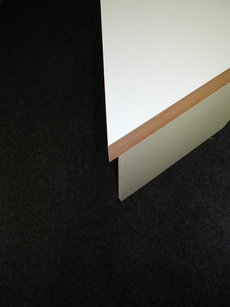 Modernes Arbeitszimmer mit Arbeitsplatz, weißer Wandfarbe, Teppichboden, freistehendem Schreibtisch und grauem Boden in Berlin