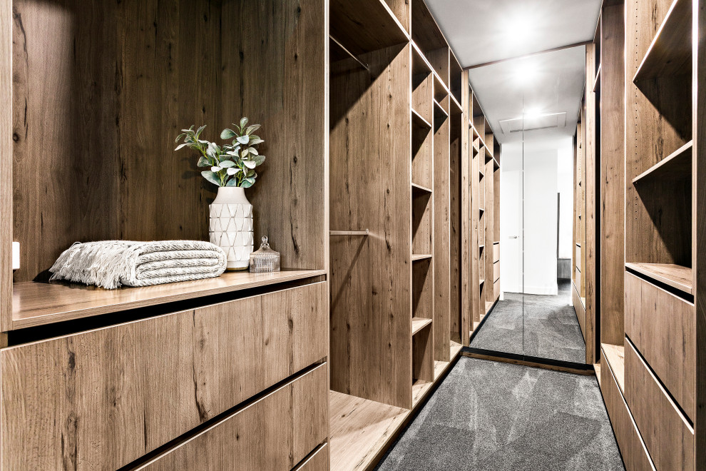 Réalisation d'un petit dressing minimaliste en bois brun neutre avec placards, moquette, un sol gris et différents designs de plafond.