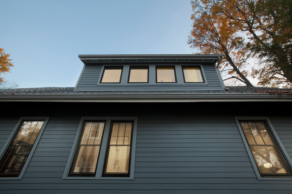 Mid-sized contemporary two-storey grey house exterior in Indianapolis with concrete fiberboard siding, a gable roof and a metal roof.