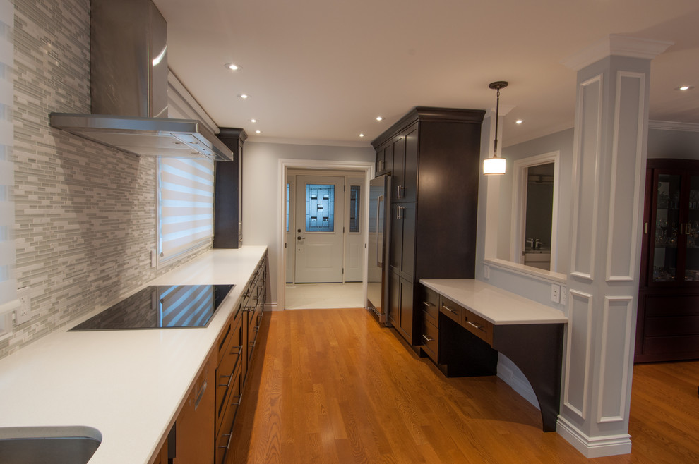 Example of a large transitional galley light wood floor enclosed kitchen design in Toronto with a single-bowl sink, shaker cabinets, dark wood cabinets, quartzite countertops, beige backsplash, stone tile backsplash, stainless steel appliances and an island