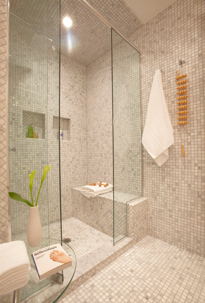 Photo of a mid-sized contemporary master bathroom in Toronto with flat-panel cabinets, light wood cabinets, a one-piece toilet, gray tile, grey walls, marble floors, a drop-in sink, an alcove shower, marble, grey floor, a hinged shower door, a niche and a shower seat.