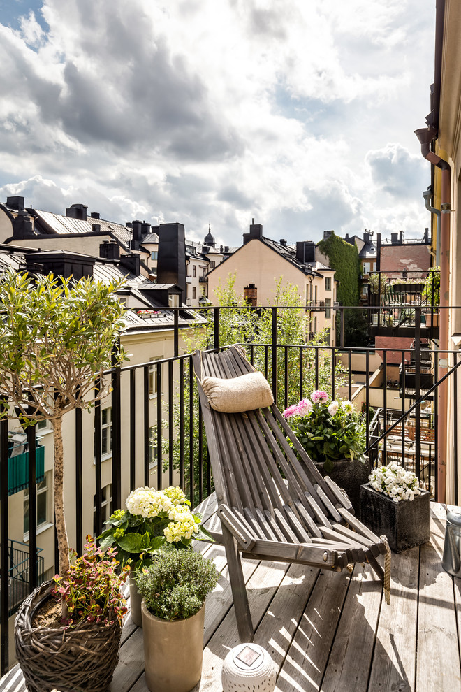 This is an example of a small scandinavian balcony in Stockholm with a container garden, no cover and metal railing.