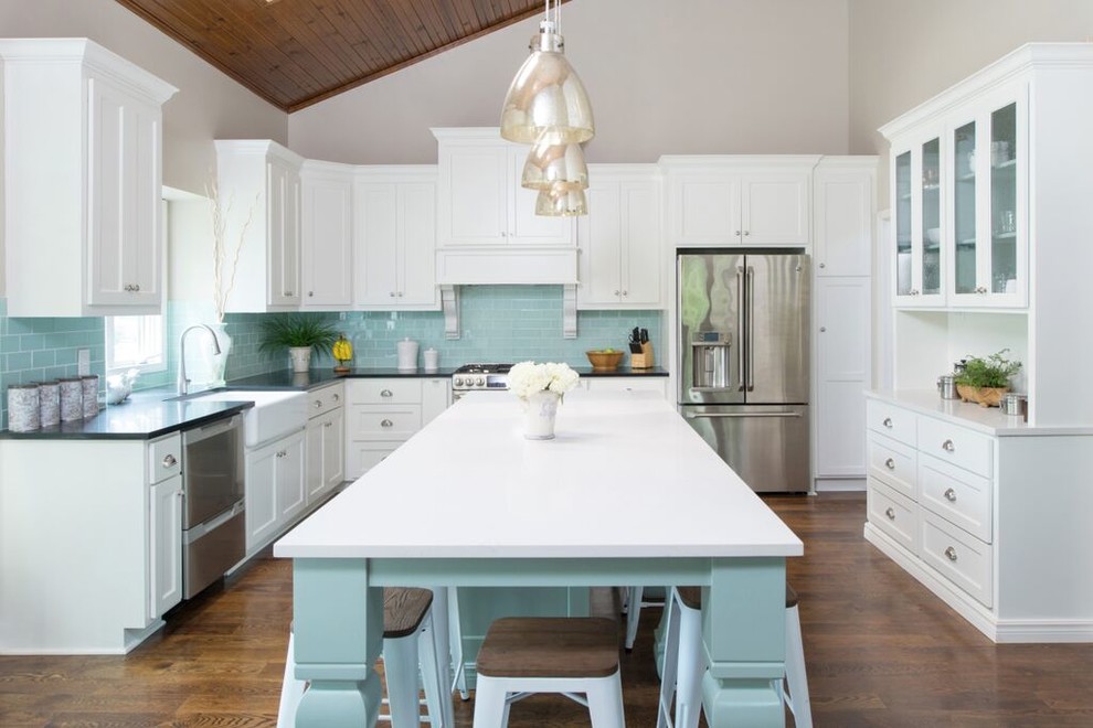 Design ideas for a transitional u-shaped kitchen in Kansas City with a farmhouse sink, white cabinets, quartz benchtops, blue splashback, glass tile splashback, stainless steel appliances, with island and flat-panel cabinets.