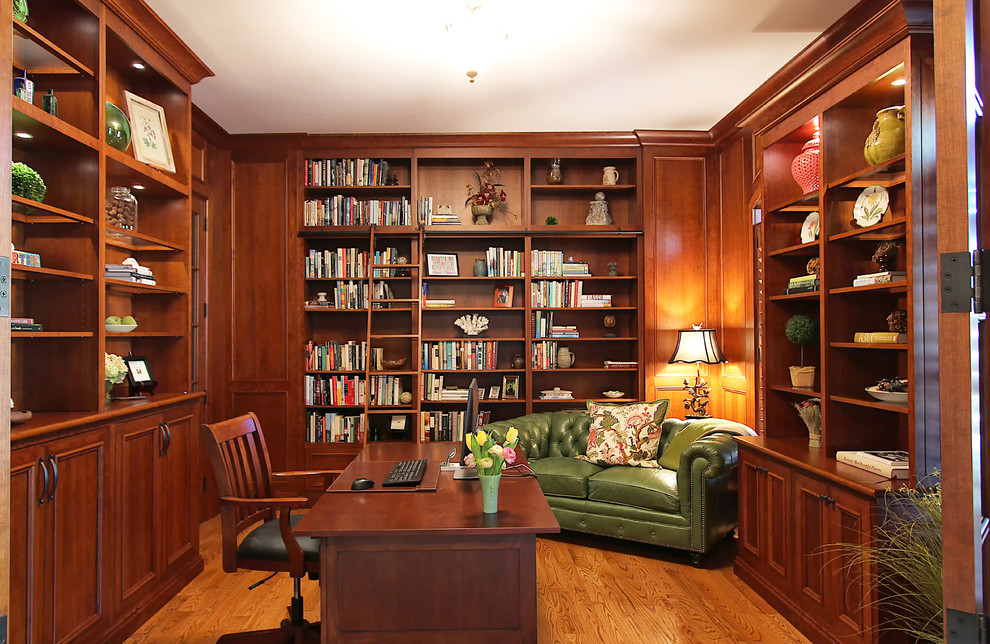 Design ideas for a mid-sized traditional home office in Charlotte with a library, medium hardwood floors and a freestanding desk.