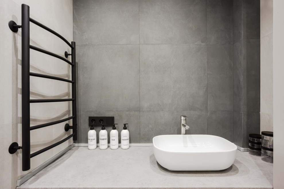 Modern inredning av ett mellanstort grå grått en-suite badrum, med släta luckor, grå skåp, ett platsbyggt badkar, en dusch/badkar-kombination, en vägghängd toalettstol, grå kakel, klinkergolv i keramik, ett fristående handfat, grått golv och med dusch som är öppen