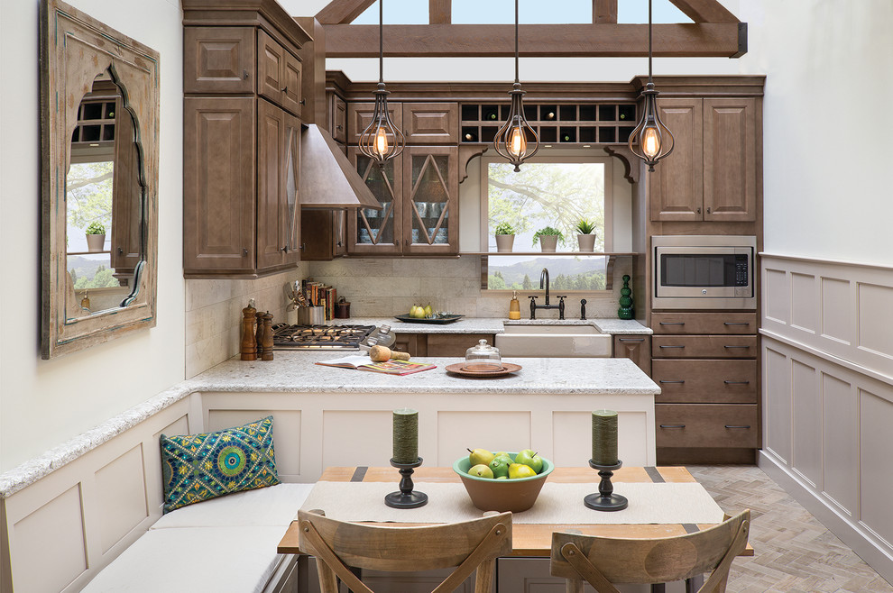 This is an example of a traditional u-shaped eat-in kitchen in Burlington with a farmhouse sink, raised-panel cabinets, dark wood cabinets, beige splashback, stainless steel appliances and a peninsula.