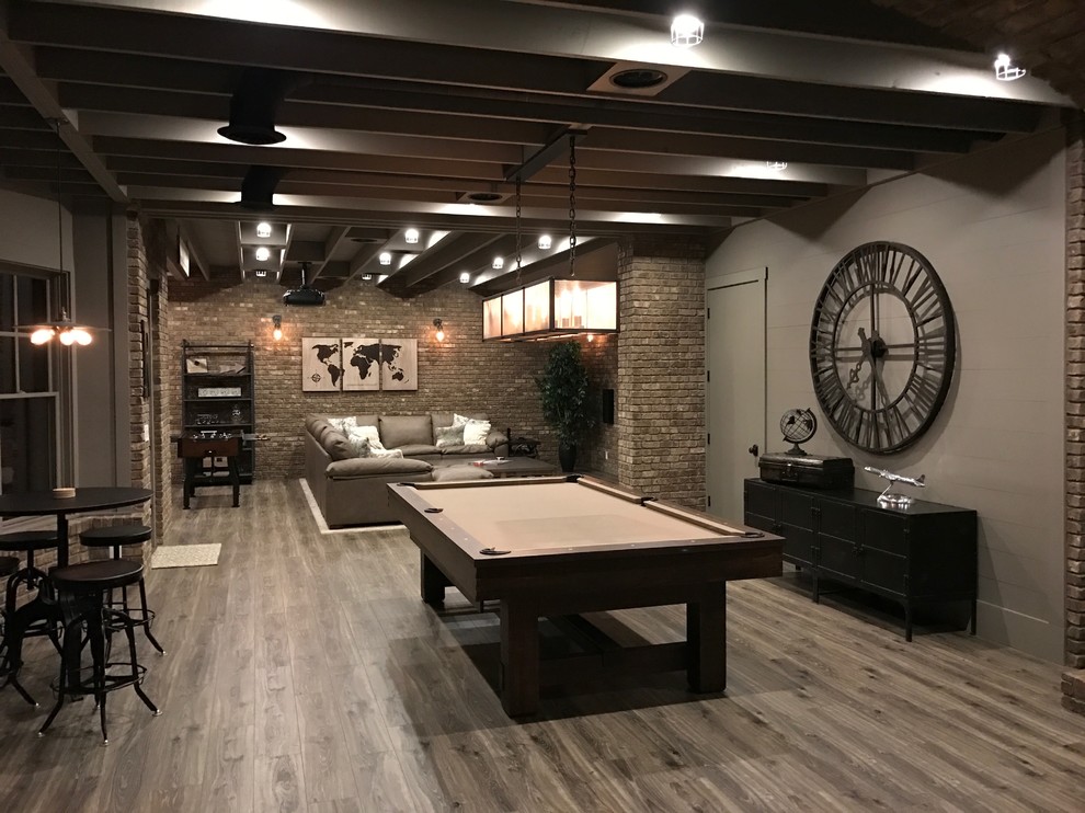 Design ideas for a mid-sized industrial walk-out basement in Atlanta with brown walls, laminate floors, no fireplace and brown floor.