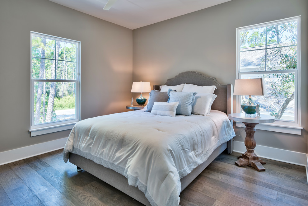 Mid-sized beach style guest bedroom in Other with brown walls, light hardwood floors, no fireplace and brown floor.