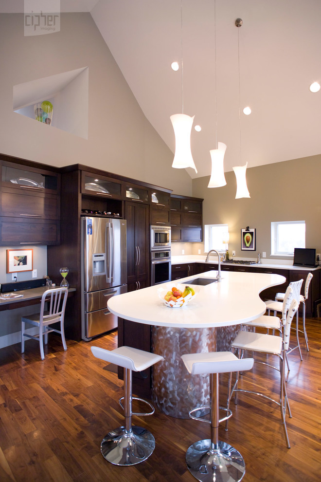Inspiration for a mid-sized transitional l-shaped medium tone wood floor and brown floor open concept kitchen remodel with an undermount sink, flat-panel cabinets, dark wood cabinets, stainless steel appliances, beige walls, an island and quartz countertops