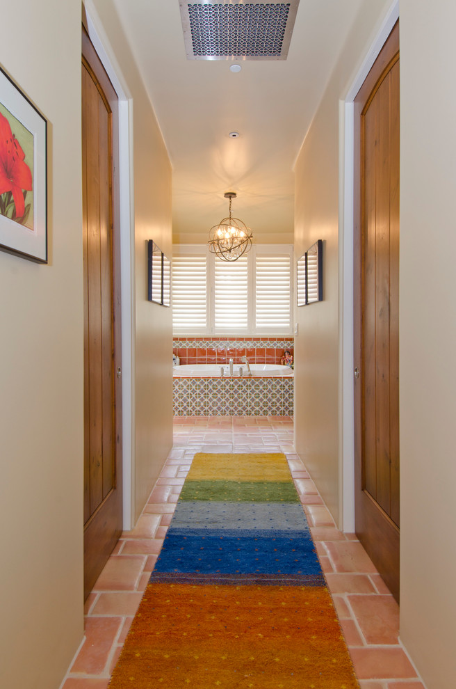 Photo of a mid-sized hallway in Phoenix with beige walls and terra-cotta floors.