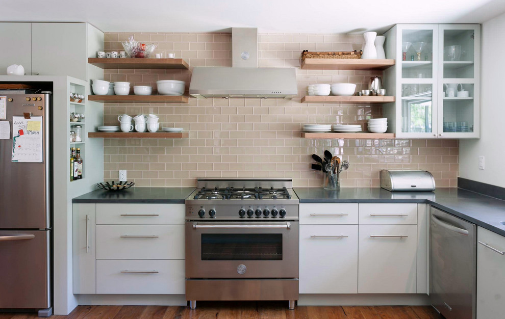 Example of a transitional medium tone wood floor kitchen design with raised-panel cabinets, white cabinets, granite countertops, beige backsplash, glass tile backsplash and stainless steel appliances