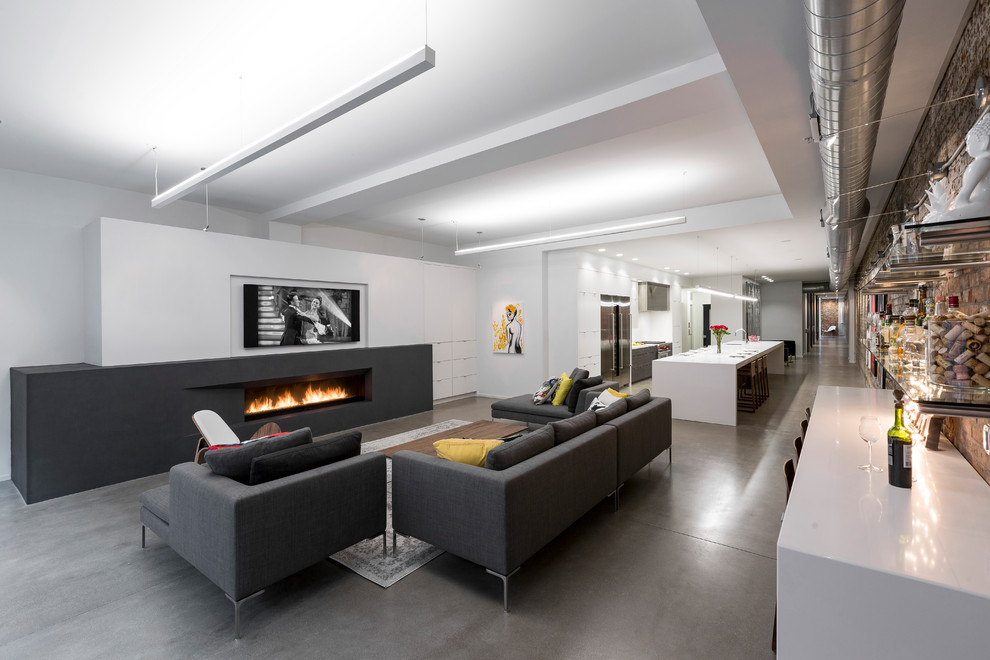 This is an example of a contemporary living room in Cincinnati with white walls, concrete floors, a ribbon fireplace and grey floor.