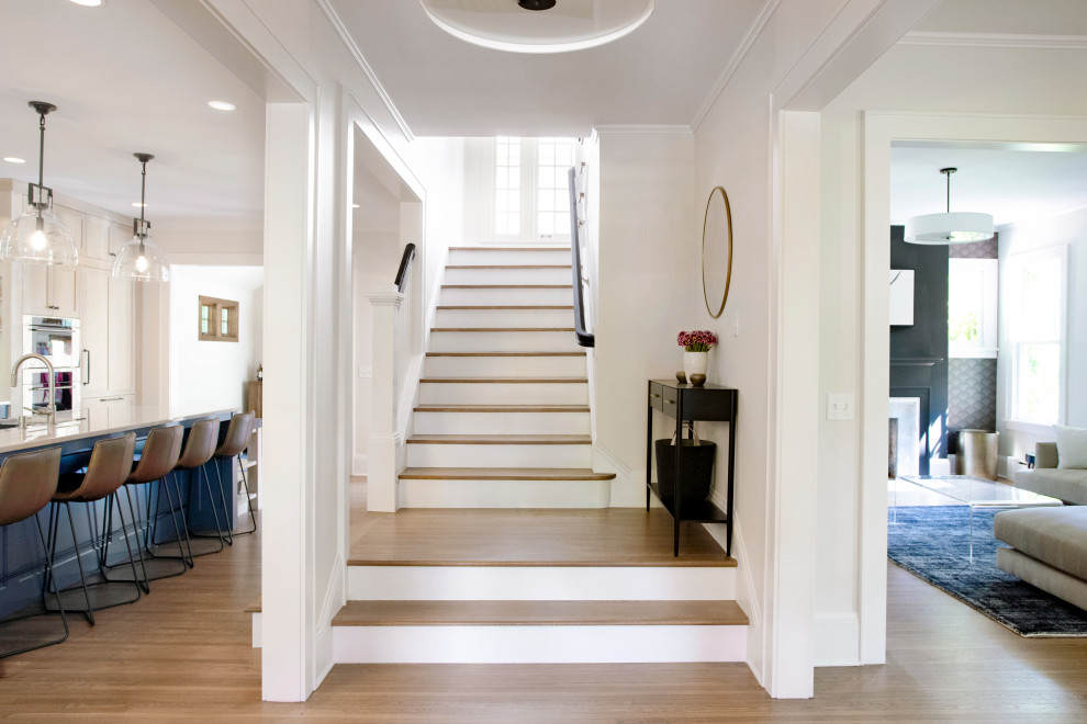 Design ideas for a large transitional wood u-shaped staircase in Minneapolis with painted wood risers and wood railing.