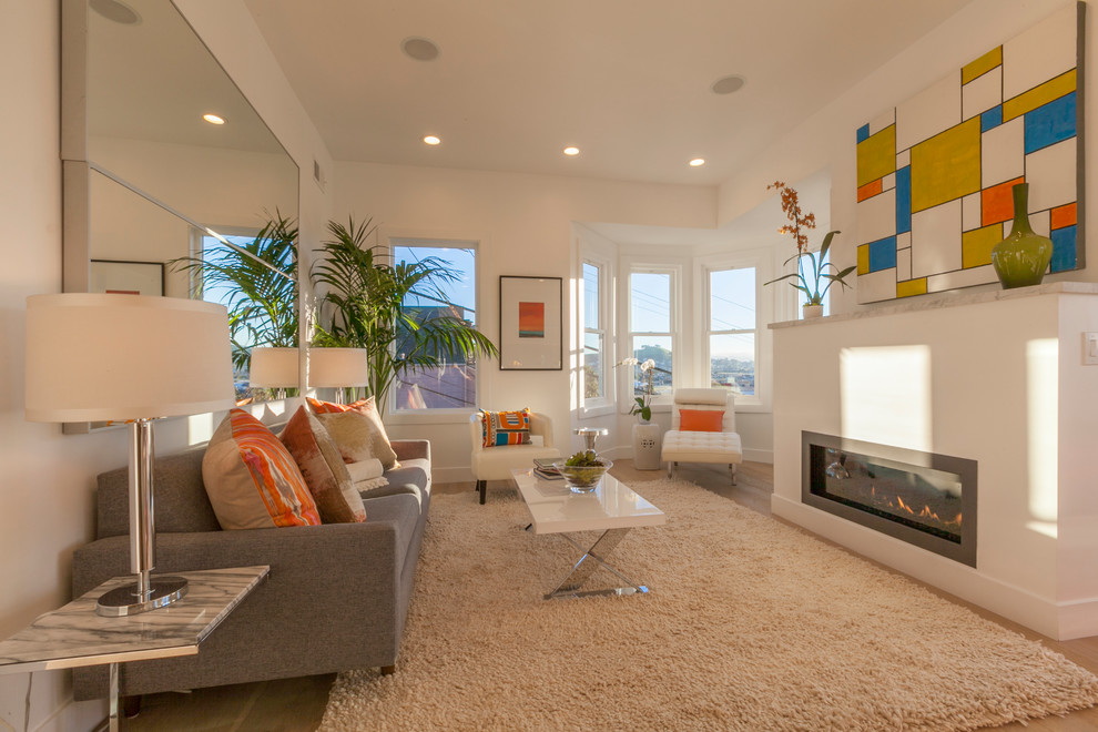 Photo of a mid-sized contemporary open concept living room in San Francisco with white walls, light hardwood floors, a ribbon fireplace, a plaster fireplace surround and no tv.