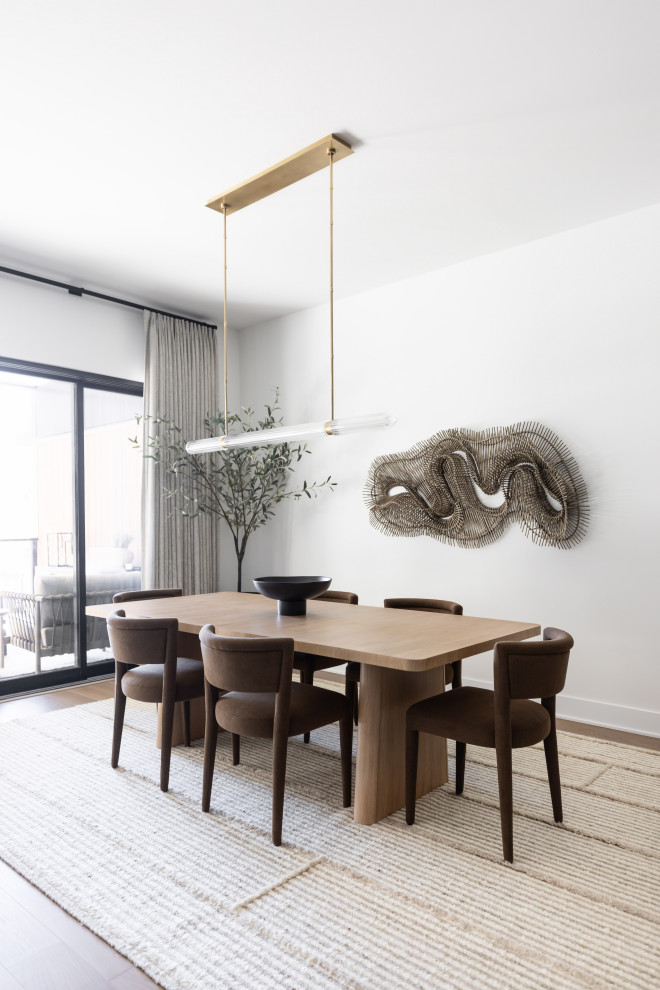 Example of a trendy medium tone wood floor and brown floor dining room design in Phoenix with white walls