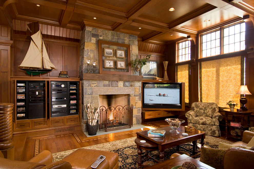 This is an example of a traditional family room in New York with brown walls, medium hardwood floors, a standard fireplace, a stone fireplace surround and a built-in media wall.