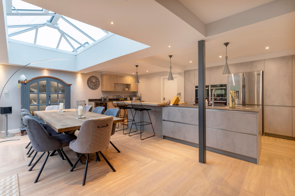 This is an example of a large contemporary l-shaped kitchen in Cheshire with flat-panel cabinets and with island.
